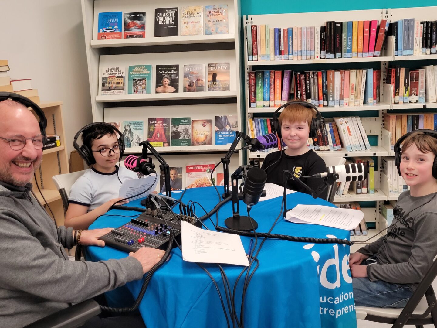 Jeunes réunis autour de microphones pour créer un balado.