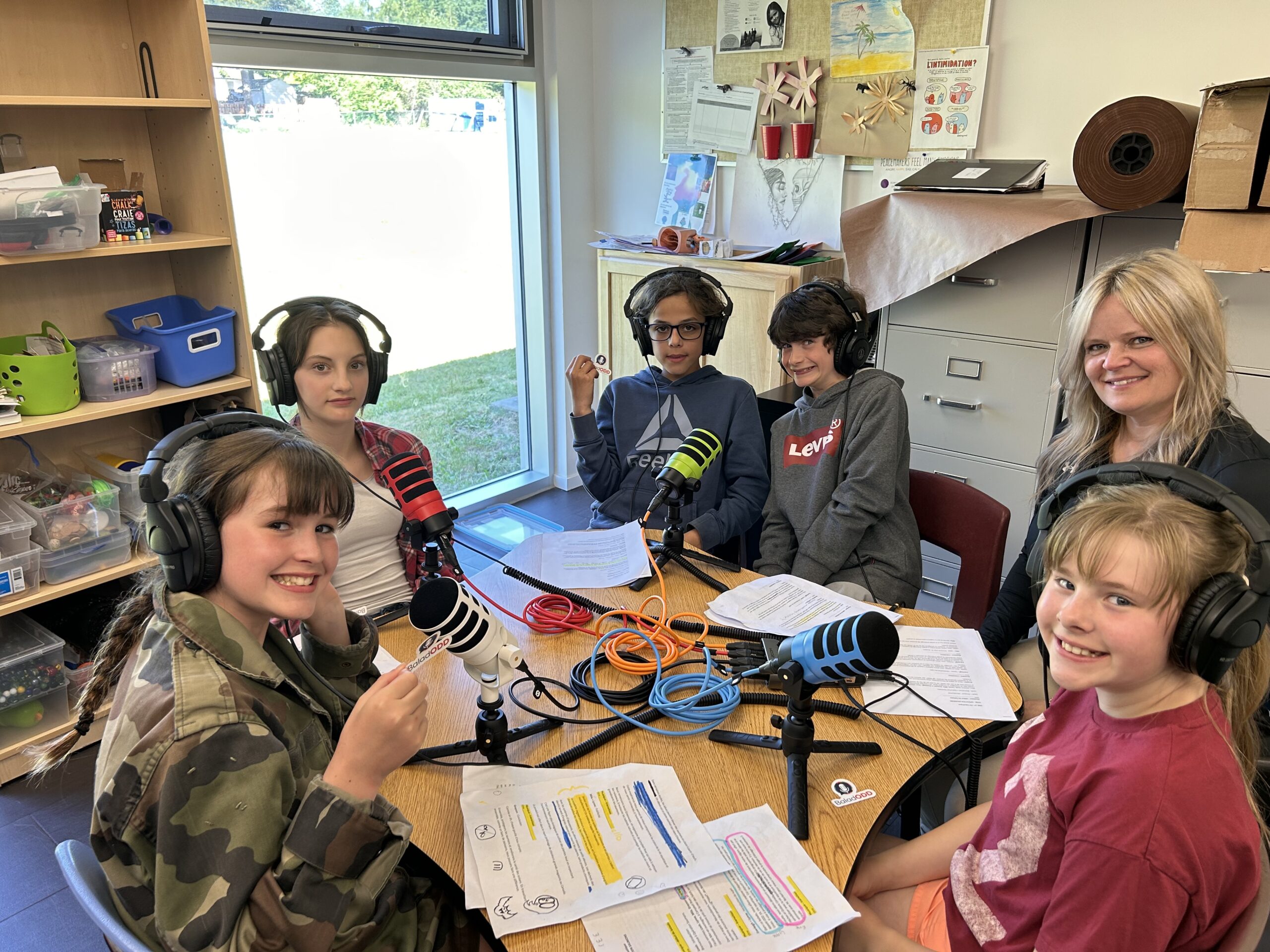 Des jeunes réunis autour de microphones pour réaliser un balado